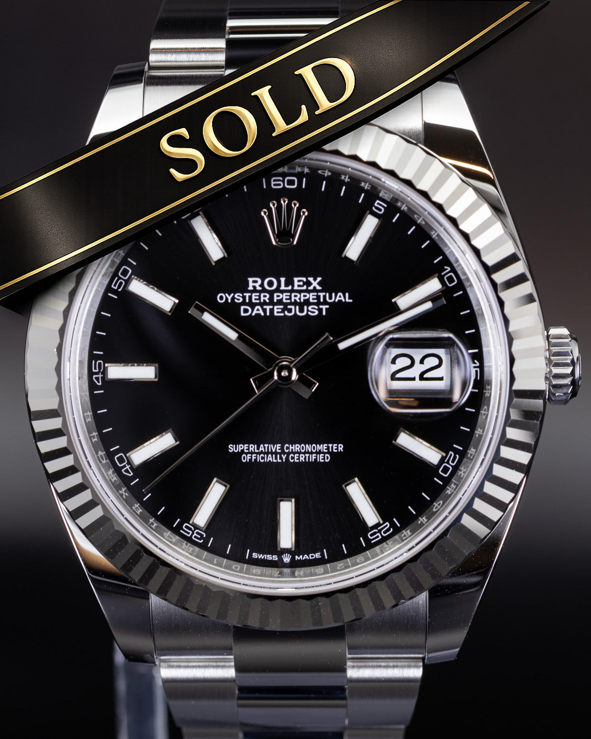 Rolex watch with a 'SOLD' ribbon on a dark background