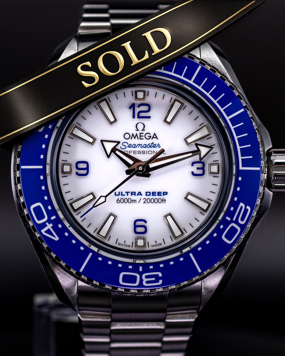 Omega Seamaster watch with blue bezel and 'SOLD' banner on a dark background