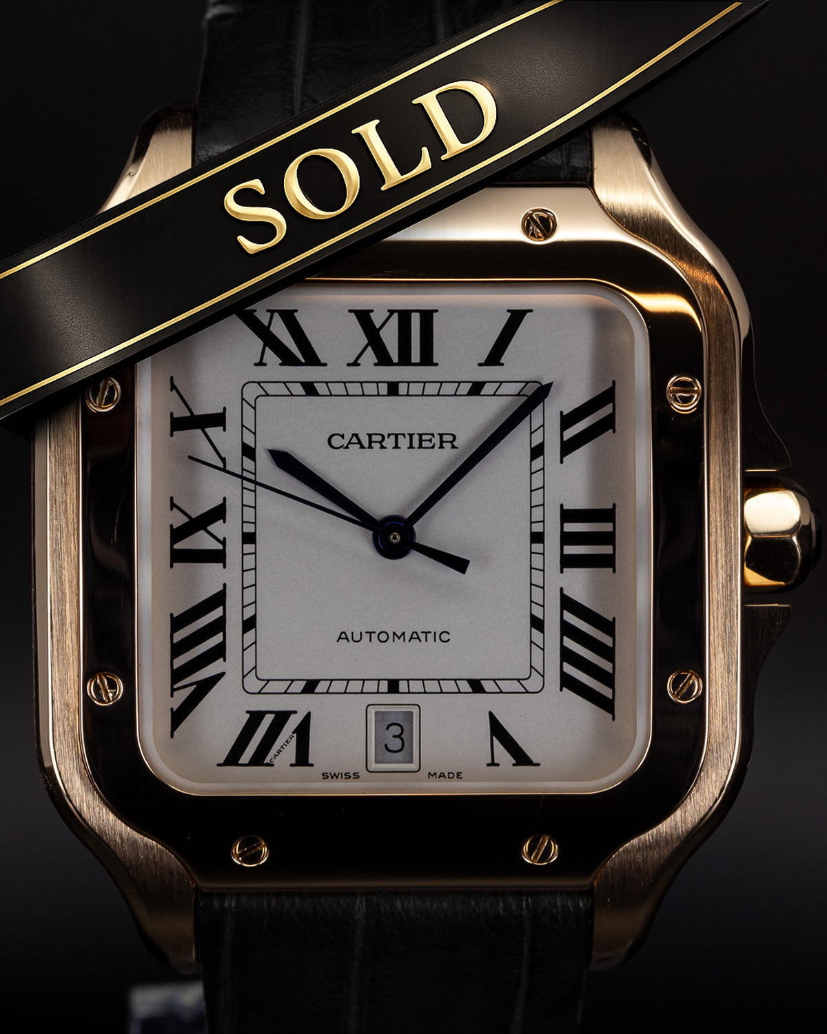 Cartier watch with a 'SOLD' ribbon on a black background