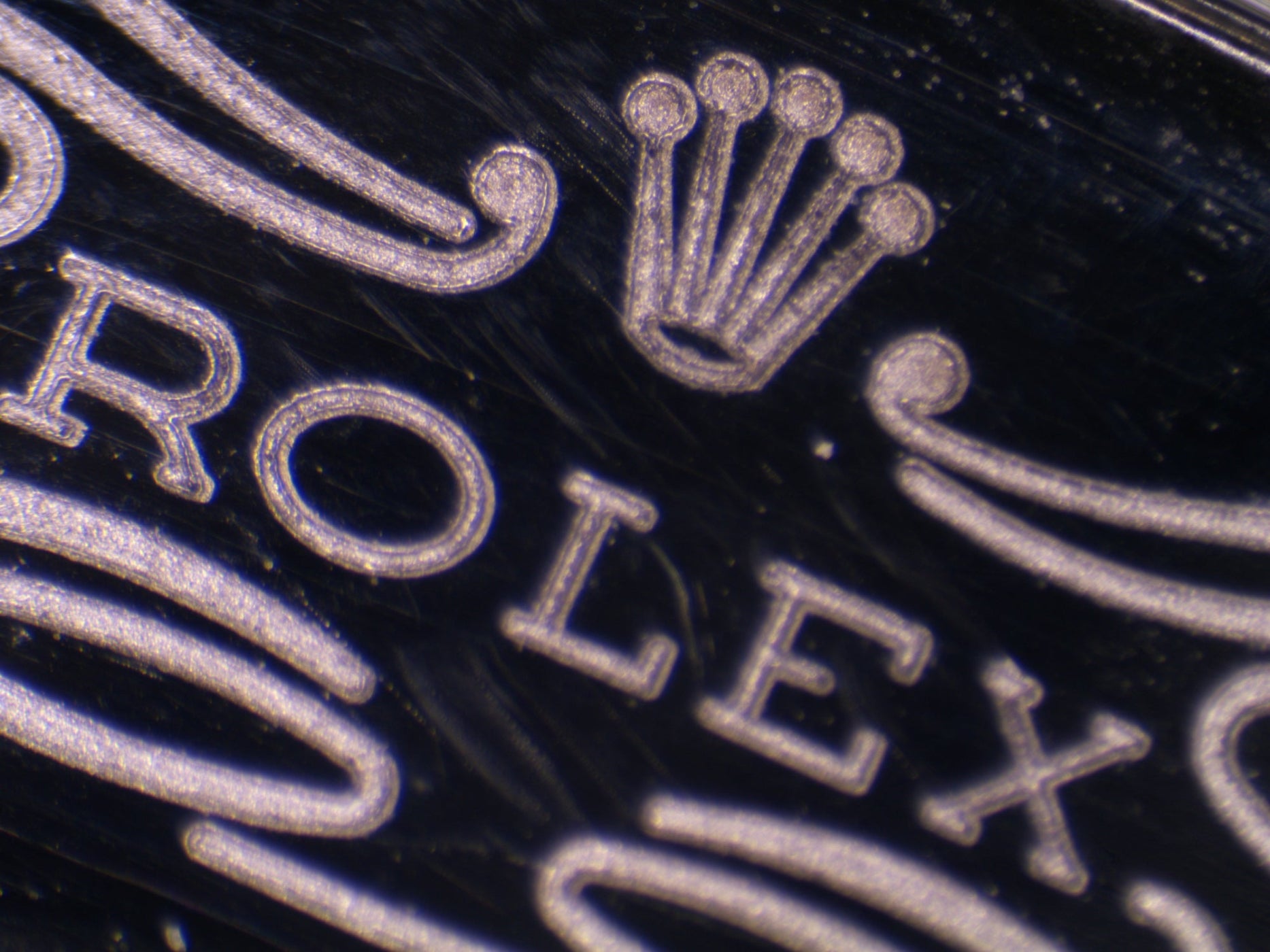 Close-up macro image of a Rolex logo on stainless steel bracelet clasp